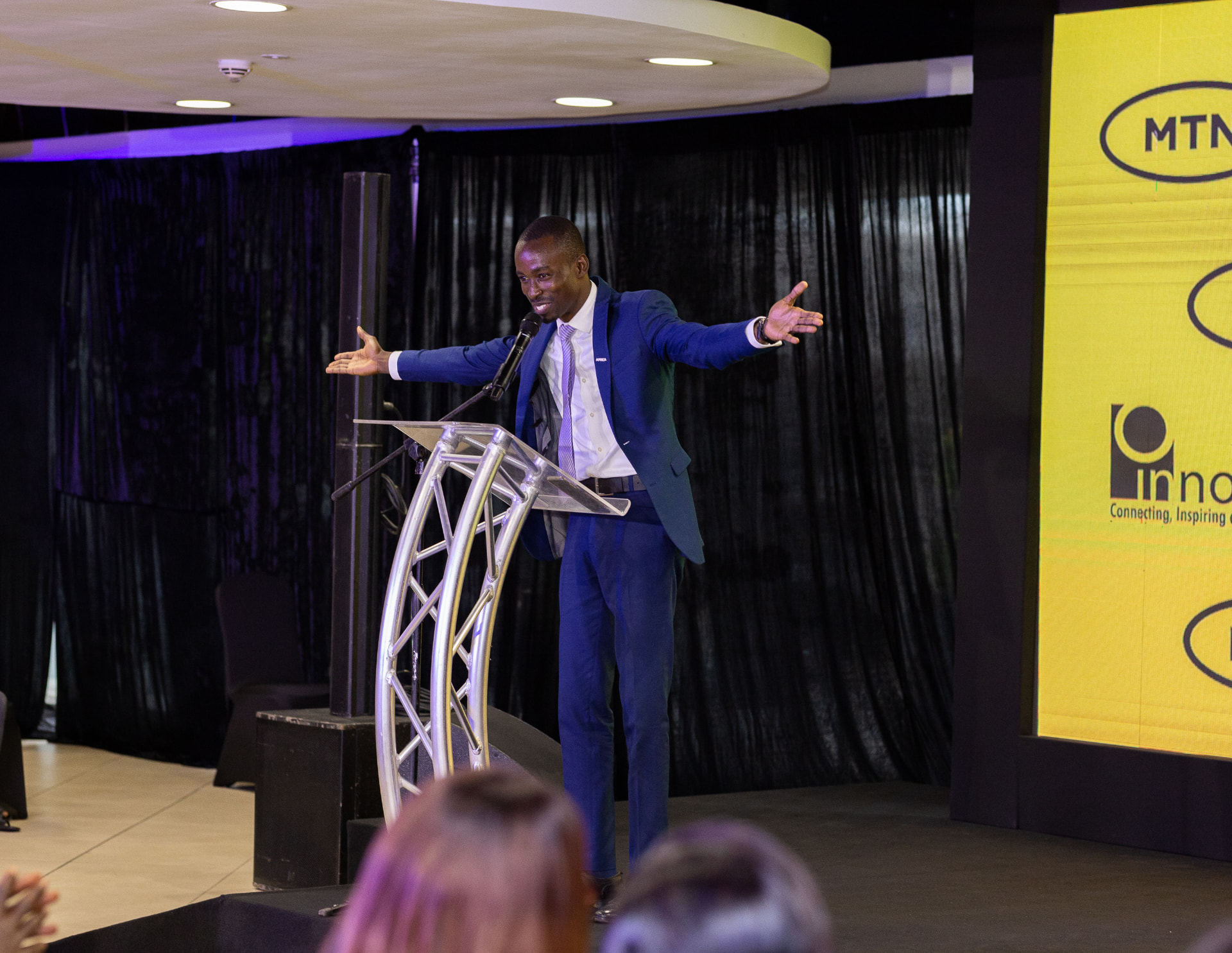 King David Amo on stage mid-address at a corporate innovation event