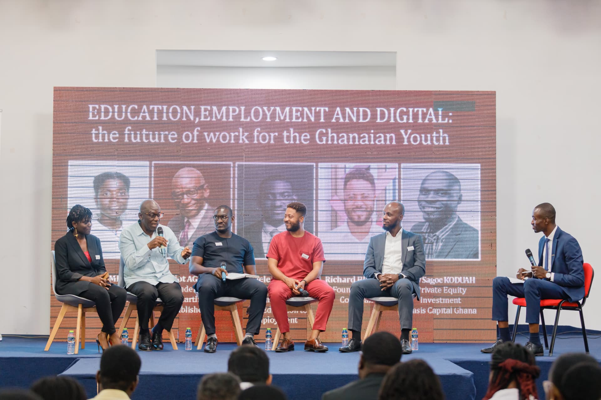King David Amo moderating a five-person panel on a stage titled Education, Employment and Digital