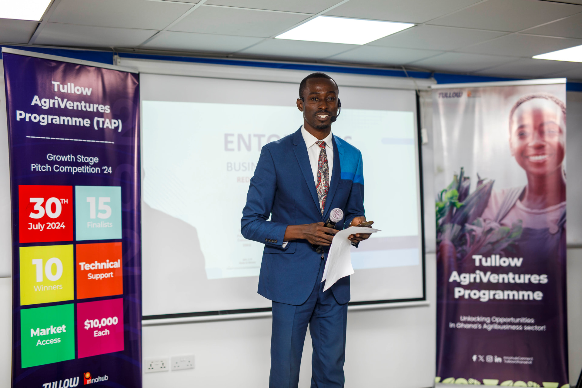 King David Amo with a headset microphone presenting in front of a projector screen